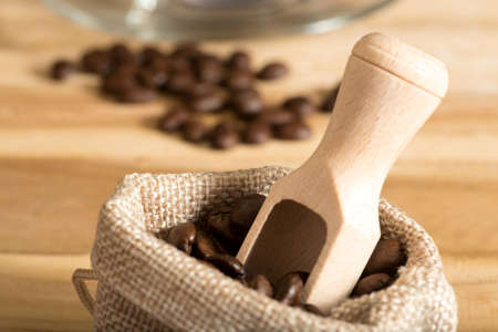 Bag with coffee beans and wooden spatulaの写真素材