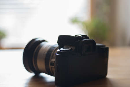 An old analog camera on a table by the windowの写真素材