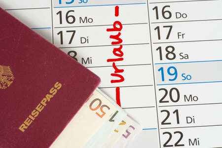 A german passport, euro bills and a date for holidays in a calendarの写真素材