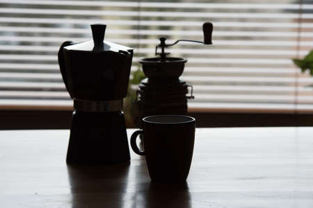 An espresso cooker, coffee grinder and a cupの写真素材