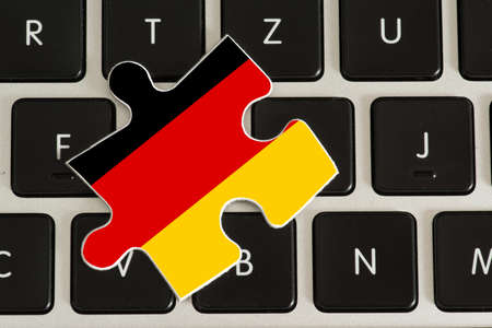 A computer and a puzzle part with the flag of Germanyの写真素材