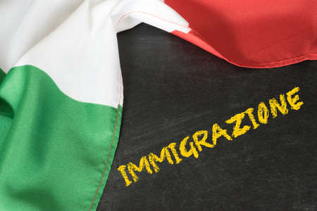 Italian flag, chalk board and the word Immigration