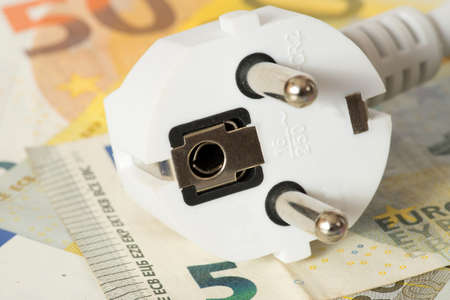 An electric plug and many euro banknotes