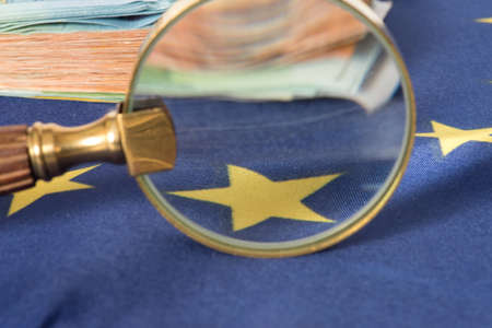 Flag of the European Union EU, a magnifying glass and euro billsの写真素材