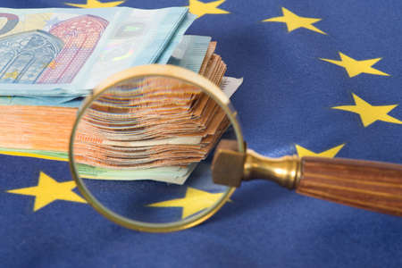 Flag of the European Union EU, a magnifying glass and euro billsの写真素材