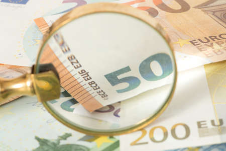 Euro bills and a magnifying glassの写真素材