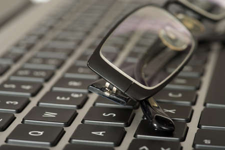 A laptop keyboard and glassesの写真素材