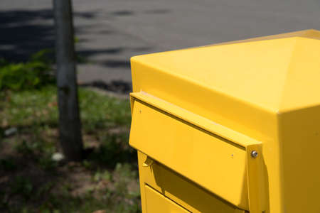 A yellow mailbox on a streetの写真素材