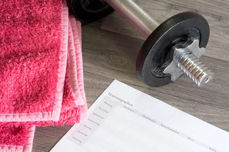 A dumbbell, towel and training plan for weight training