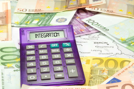The map of Germany, euro bills and a calculator for the cost of integration of refugeesの写真素材