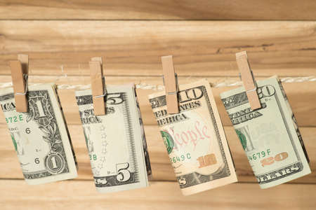 Dollar bills on a clothesline with clothespinの写真素材