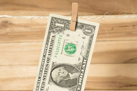 One dollar bill on a clothesline with clothespinの写真素材