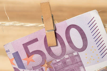 A 500 EURO bill on a clothes line with a clothespinの写真素材
