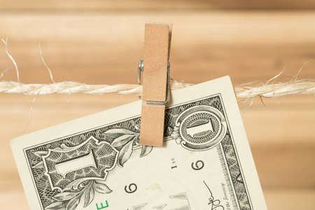 One dollar bill on a clothesline with clothespinの写真素材