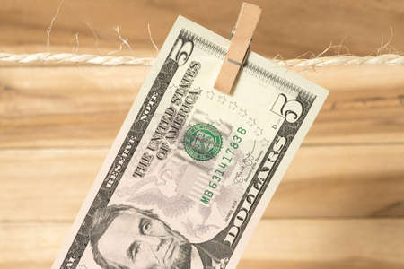 A $ 5 bill on a clothes line with a clothespinの写真素材
