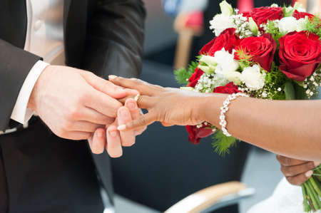 A bridal couple exchanges wedding ringsの写真素材
