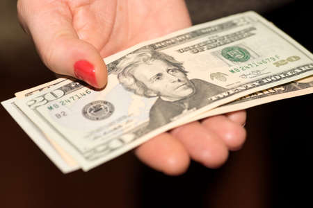 A woman holds dollar bills in her hand