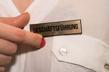A woman and a name tag with the imprint Business Management