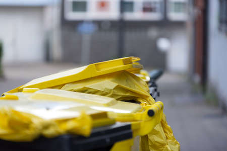 Yellow garbage cans and garbage bagsの写真素材