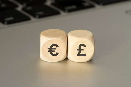 A computer and dice with symbols for Euro and English Poundsの写真素材