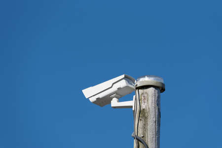 A security camera and blue sky in the background