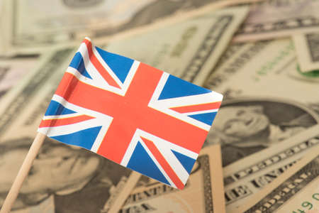 Flag of Great Britain and dollar bills in the backgroundの写真素材