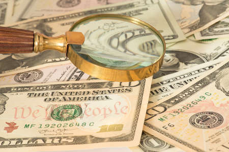 Dollar bills and a magnifying glassの写真素材