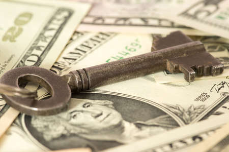 Dollar bills and a key for a flat or a houseの写真素材
