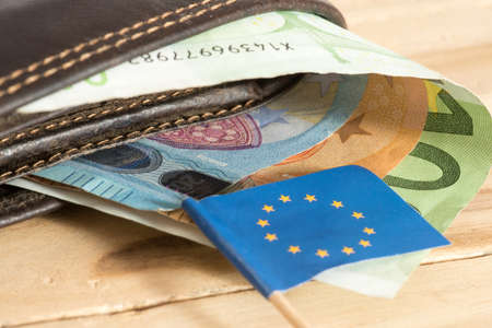 Flag of the European Union EU, a yellow wallet and Euro banknotes