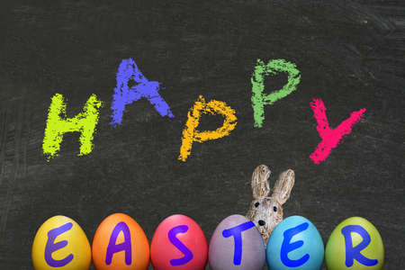 Easter eggs, an Easter bunny and chalkboard with the slogan Happy Easter