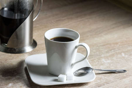 A cup of fresh coffee and cubes of sugar