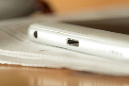 A newspaper, reading glasses and a smartphone