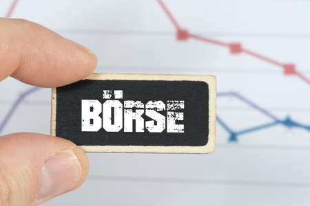 A man is holding a signboard with the imprint stock market in front of a diagramの写真素材