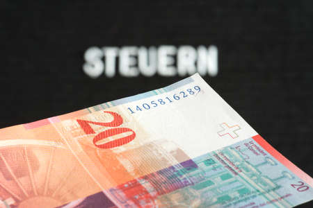 A Swiss Franc CHF banknote and taxes in Switzerland