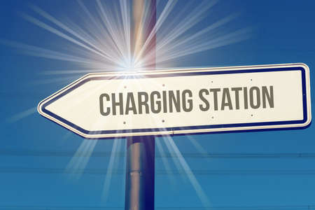 A sign points towards a charging station for electric carsの写真素材