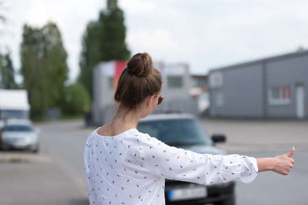 A woman wants to hitchhike in a carの写真素材
