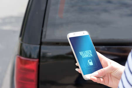 A car and smartphone with search for cheap gas station