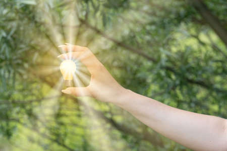 A young woman with a lightbulb as a symbol of an ideaの写真素材