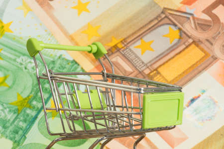 A shopping cart and lots of euro banknotesの写真素材