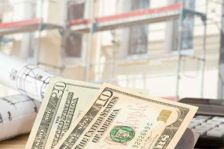 Dollars money, blueprints and construction site for a houseの写真素材