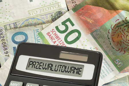 Money Swiss franc and Polish zloty, calculator and polish word for currency conversionの写真素材