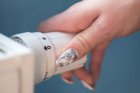 A woman turns on the heaterの写真素材