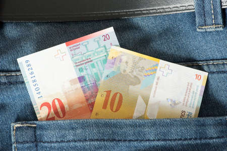 Banknotes Swiss francs CHF in trouser pocket of a pair of jeansの写真素材