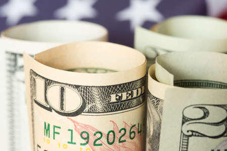 Close up of dollar banknotes and American flagの写真素材