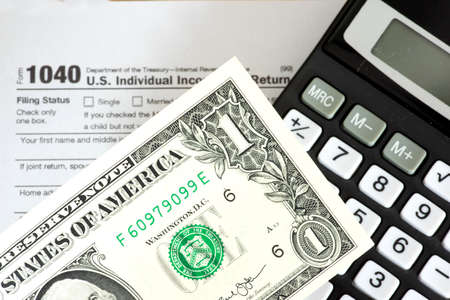 Dollar bill, calculator and tax return form 1040の写真素材