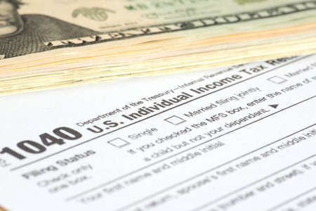 Dollar banknotes and form 1040 for tax return