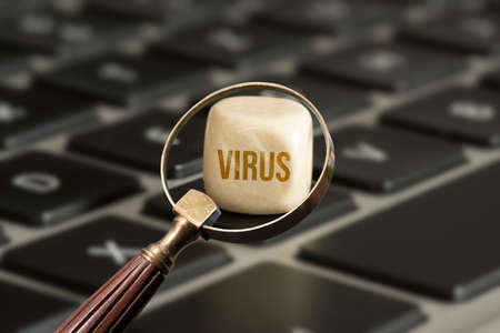 Magnifying glass, computer and a virus