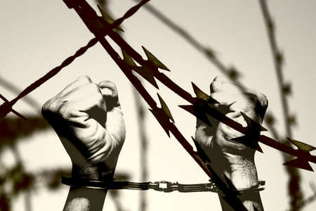 Barbed wire and hands handcuffedの写真素材