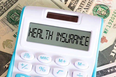 Dollar bills, calculators and health insurance in Americaの写真素材
