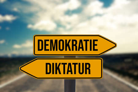 Signposts point to democracy and dictatorshipの写真素材